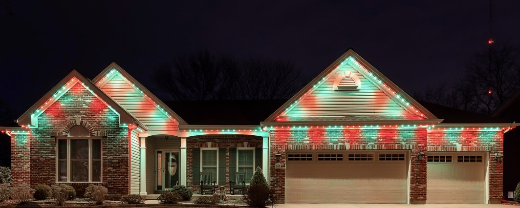Brick ranch home with permanent lighting tracing every roofline in a red and green pattern