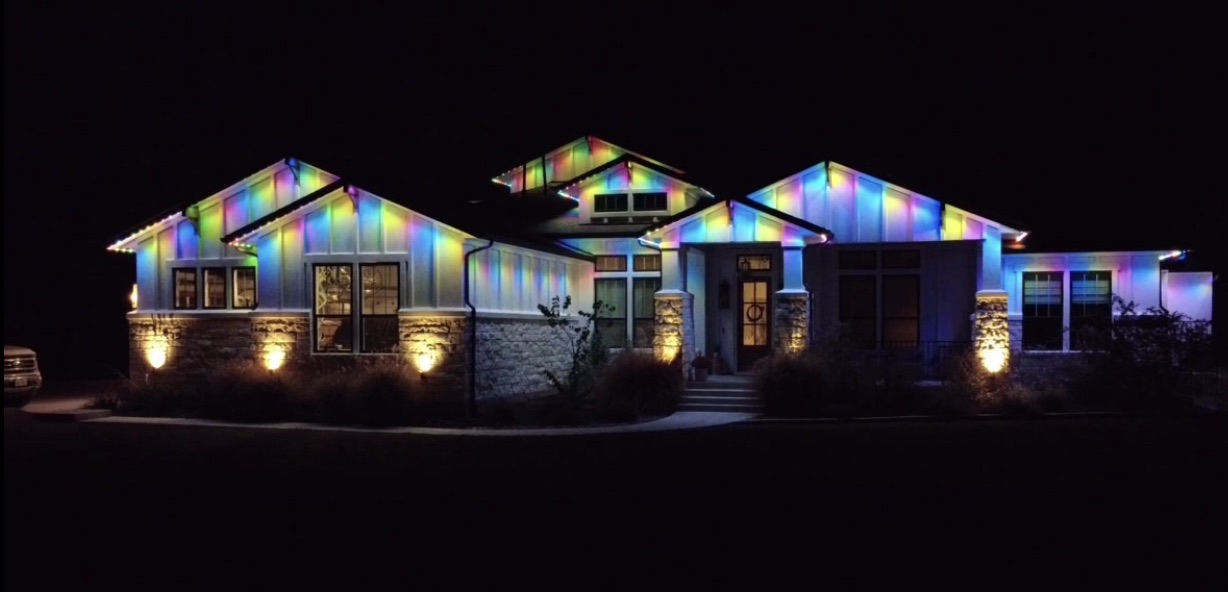 Home roofline lit in a full rainbow color gradient, showing the system's full color range